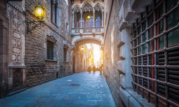 calle estrecha con puente popular en el barrio gótico al atardecer, barcelona